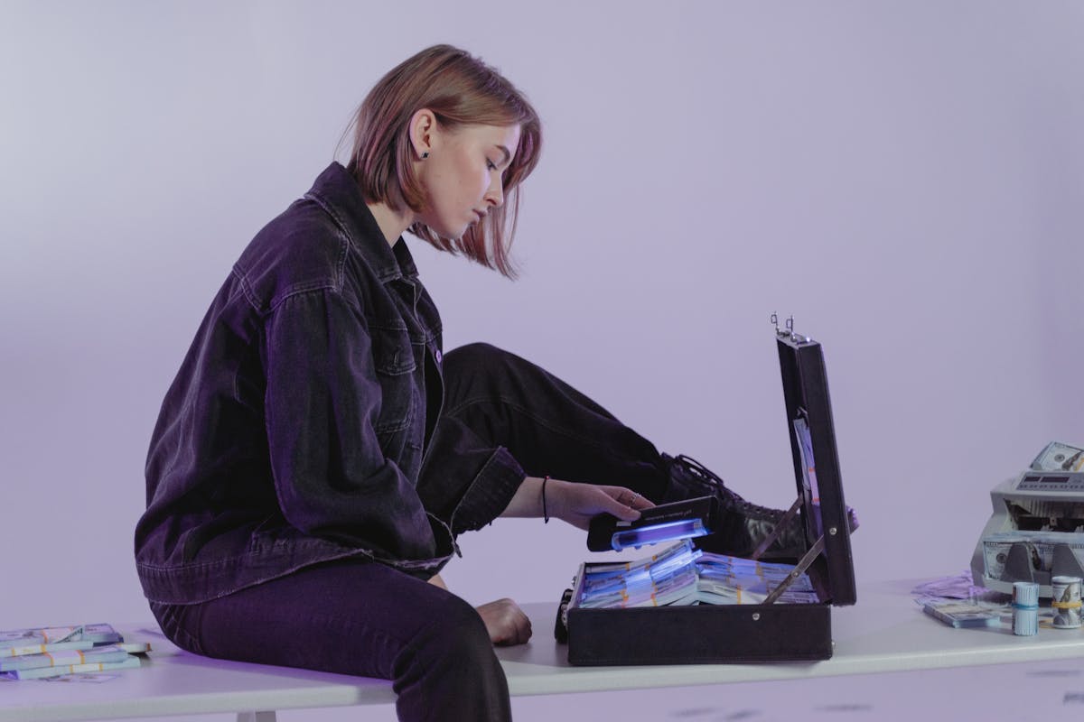 Woman in Black Jacket Sitting on White Table