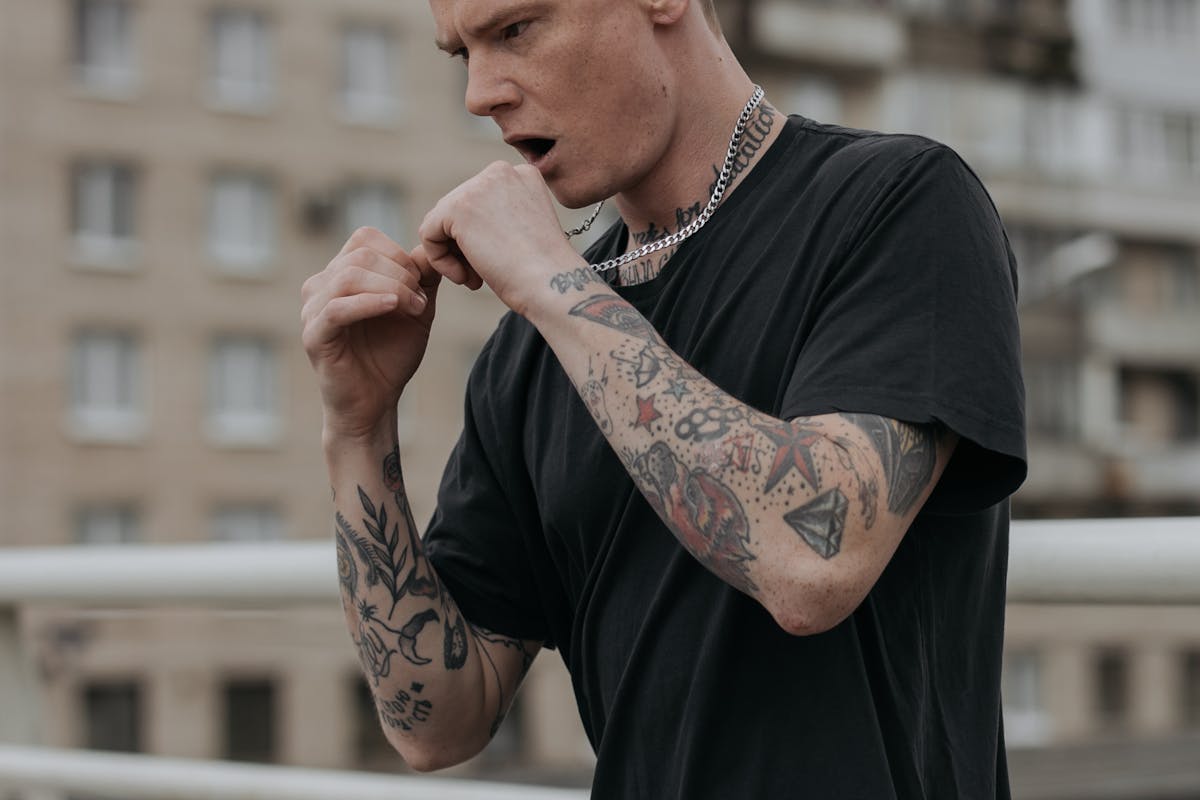 A Man in Black Crew Neck T-shirt With Tattoo on His Arms