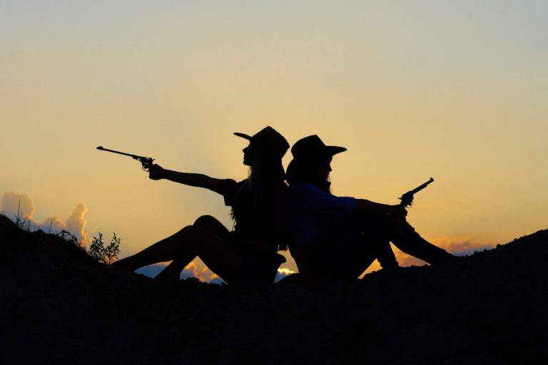Silhouette of Two People Holding Revolver Pistols